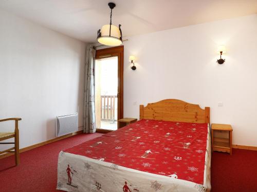 une chambre avec un grand lit avec une couverture rouge dans l'établissement A209- Appartement 2 pieces cabine 6 personnes, à Orcières