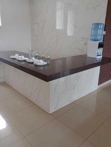 a counter with plates and wine glasses on it at Pousada Gostoso Paradise in São Miguel do Gostoso