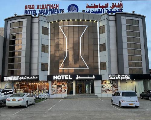a hotel with two cars parked in front of it at AFAQ AL BATINAH - SAHAM in Şaḩam
