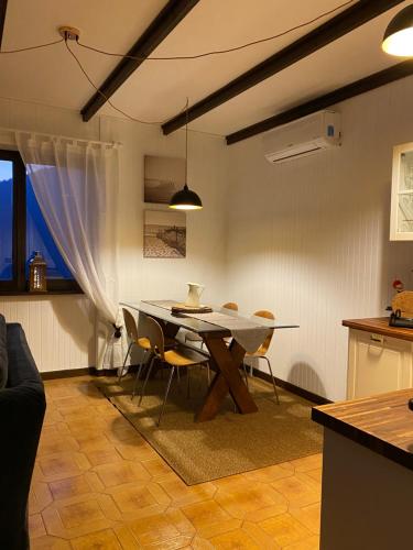 cocina y comedor con mesa y sillas en LA PLAYA Cottage con spiaggia privata, en Pettenasco
