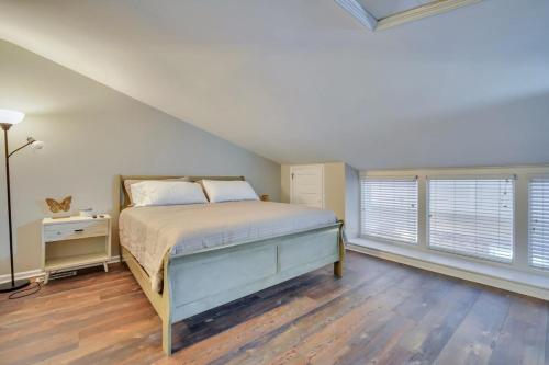 a bedroom with a bed and two windows at Downtown Loft - Above Bull & Barrel & Close to Georgia Southern in Statesboro