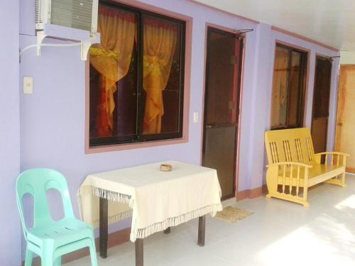 a dining room with a table and two chairs at Pabua's Cottages in Mambajao