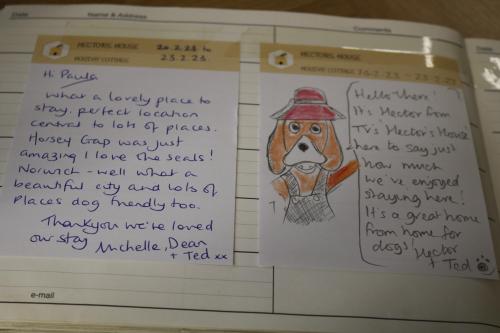 a notebook with a drawing of a dog in a hat at Hectors house in Ormesby Saint Michael