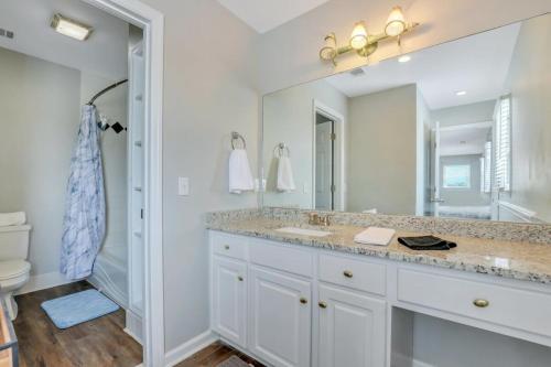 a bathroom with a sink and a large mirror at Eagle's Nest - Spacious Loft Downtown - Near GSU in Statesboro