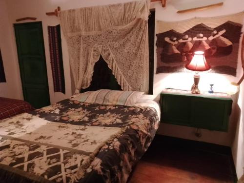 una camera con letto a baldacchino e lampada di Country House Chulumani a Chulumani