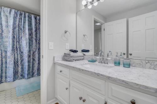 a white bathroom with a sink and a mirror at Eagle Creek Loft - Close to Shops Food GSU in Statesboro