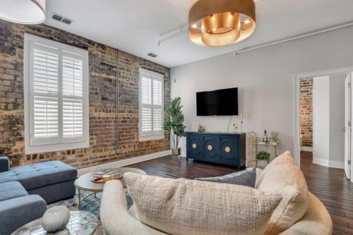 a living room with a brick wall at Broughton Street Bungalow - Steps to Everything in Savannah