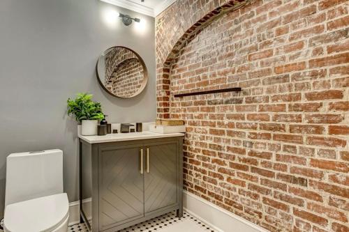 a bathroom with a brick wall and a toilet at West End Loft - Downtown 5 min walk to River St in Savannah