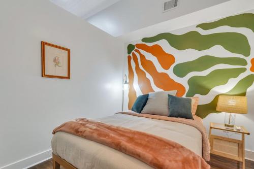 a bedroom with a bed with a painting on the wall at Broughton Bliss Loft- City Market Plant Riverside in Savannah