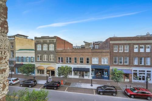 a city street with cars parked in front of buildings at Broughton Bliss Loft- City Market Plant Riverside in Savannah