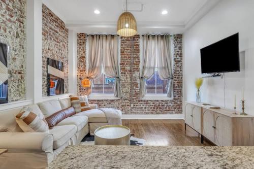 a living room with a couch and a tv at Broughton Bliss Loft- City Market Plant Riverside in Savannah