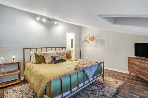 a bedroom with a bed and a flat screen tv at Eagle's Landing Loft-Downtown Above Bull & Barrel in Statesboro