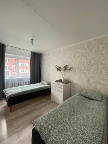 a bedroom with two beds and a window at Külaliskorter Tõrva linnas in Tõrva