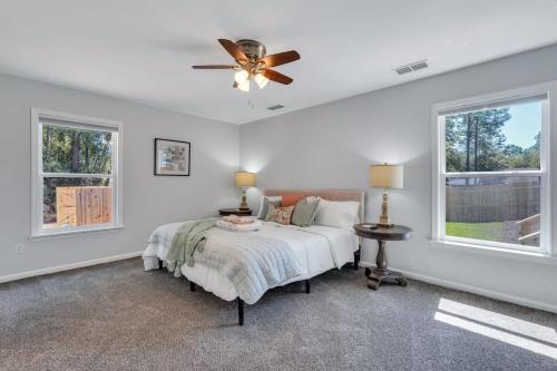 een slaapkamer met een bed en een plafondventilator bij Southern Splash Retreat Poolside Paradise by GSU in Statesboro