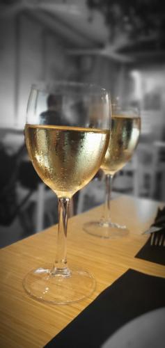 dois copos de vinho branco sentados numa mesa em Albufera Rooms em Valência