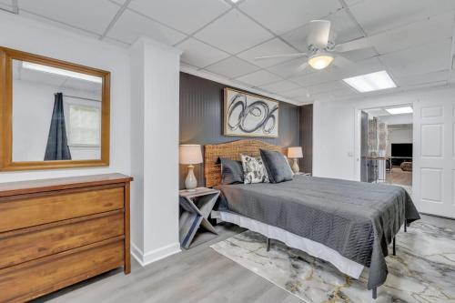 een slaapkamer met een bed, een dressoir en een spiegel bij Eagle's Nest - Upscale Loft Downtown Close to GSU in Statesboro