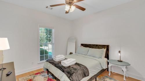 a white bedroom with a bed and a ceiling fan at Eagle's Retreat - Close to GSU & Paulson Stadium in Statesboro