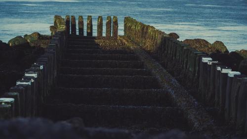 a set of stairs next to the ocean at Hotel Restaurant Solskin in Vlissingen