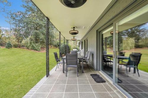 an outdoor patio with chairs and tables and windows at The Grey - Large Eclectic and Quiet Home in Statesboro