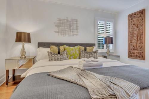 a white bedroom with a large bed and a desk at The Grey - Large Eclectic and Quiet Home in Statesboro