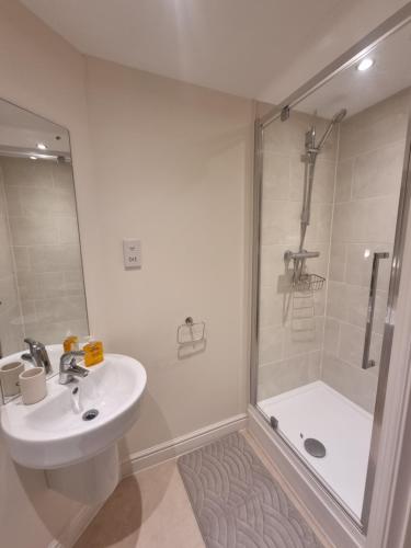 a white bathroom with a shower and a sink at Estuary view in Fleetwood