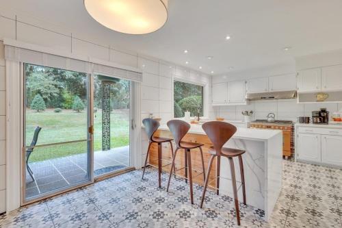 a kitchen with a table and four stools at The Grey - Large Eclectic and Quiet Home in Statesboro