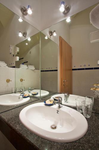 a bathroom with two sinks and a large mirror at Hotel Scaletta in Pula