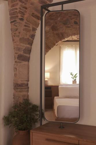 a mirror sitting on a dresser in a bedroom at enδόtera chios apartments in Chios