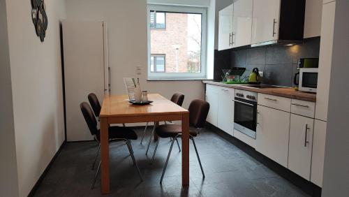 eine kleine Küche mit einem Holztisch und Stühlen in der Unterkunft Dammstraße 24-EG-ZV38 in Salzgitter