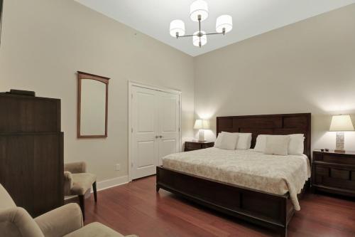ein Schlafzimmer mit einem großen Bett und einem Stuhl in der Unterkunft Downtown Loft- Steps away from Plant Riverside! in Savannah