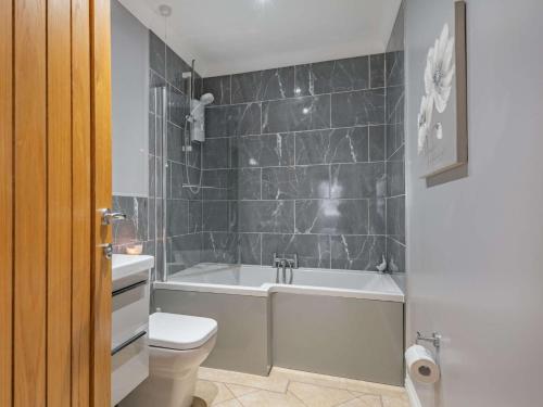 a bathroom with a tub and a toilet and a sink at 4 Bed in Manby 87031 in Manby