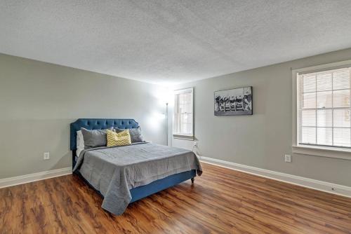 um quarto com uma cama azul e pisos em madeira em The Post Loft- In the Heart of Downtown Statesboro em Statesboro