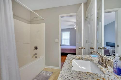 y baño blanco con lavabo y ducha. en Charming Gray Home- 5 mins from GSU!, en Statesboro