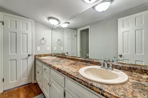 uma casa de banho com 2 lavatórios e um espelho grande em The Post Loft- In the Heart of Downtown Statesboro em Statesboro