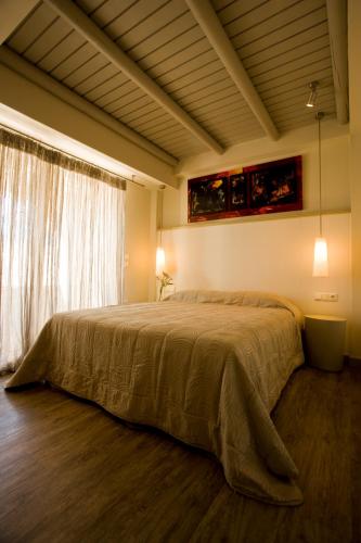 a bedroom with a bed and a large window at Princess Of Naxos in Naxos Chora