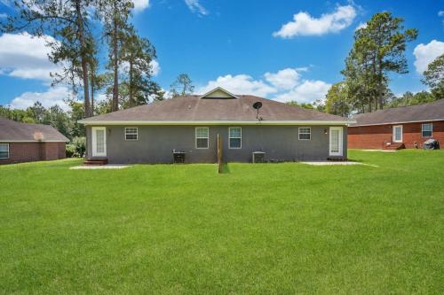 a house with a green lawn in front of it at Cozy and Contemporary Villa 1 Mile from GSU in Statesboro
