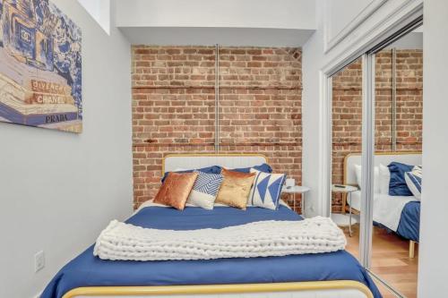 a bedroom with a bed and a brick wall at Lush Savannah Loft - Near Plant Riverside District in Savannah