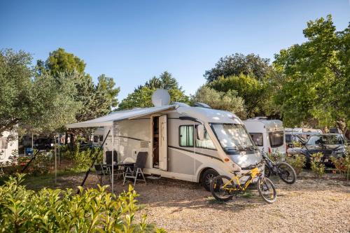 a caravan with a bike parked in front of it at Maistra Camping Amarin Pitches in Rovinj