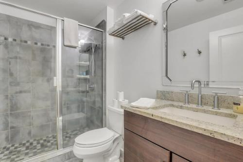 a bathroom with a shower and a toilet and a sink at Knockout Loft- Near Plant Riverside in Savannah