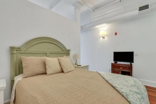 a bedroom with a large bed and a flat screen tv at Knockout Loft- Near Plant Riverside in Savannah