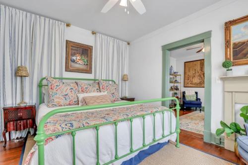 a bedroom with a green bed and a fireplace at The Graham on Oglethorpe Square in Savannah