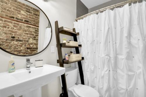 a bathroom with a sink and a toilet and a mirror at The Georgia Peach -near Plant Riverside & downtown in Savannah