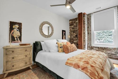 ein Schlafzimmer mit einem Bett, einer Kommode und einem Fenster in der Unterkunft The Georgia Peach -near Plant Riverside & downtown in Savannah
