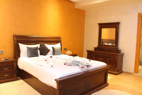 ein Schlafzimmer mit einem großen Bett und einem Spiegel in der Unterkunft Villa Perle in Marrakesch