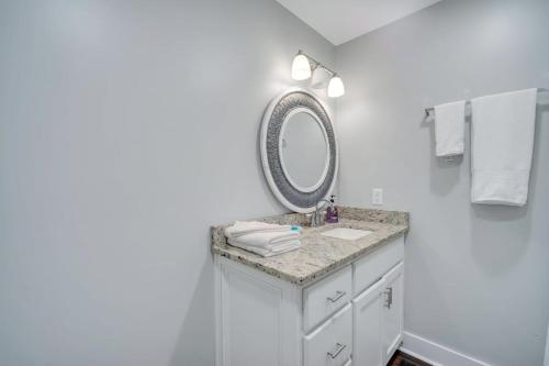 a bathroom with a sink and a mirror at Eagle Exec Loft In Downtown Statesboro in Statesboro