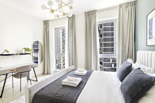 um quarto branco com uma cama e uma secretária em Silkhaus Burj Khalifa walking distance 1BDR in Downtown em Dubai