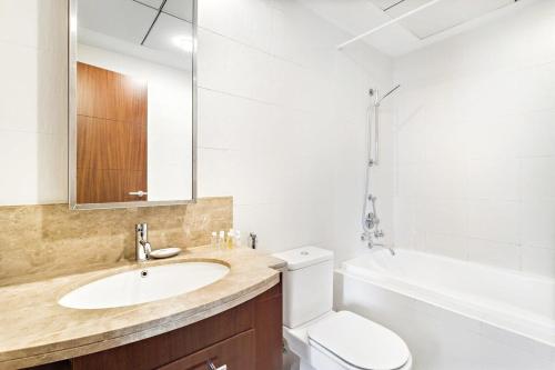 La salle de bains est pourvue d'un lavabo, de toilettes et d'une baignoire. dans l'établissement Silkhaus Burj Khalifa walking distance 1BDR in Downtown, à Dubaï