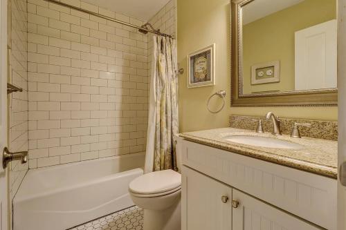 a bathroom with a toilet and a sink and a mirror at Fraser's Folly - Updated Harbour Town Villa in Hilton Head Island