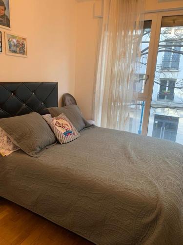 une chambre avec un grand lit avec une fenêtre dans l'établissement Pantin Bord du Canal JO 2024, à Pantin