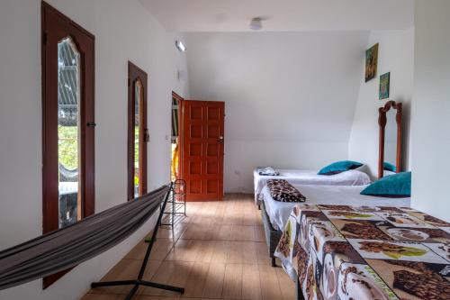 a room with two beds and a hammock in it at Paraiso de la sierra in Santa Marta